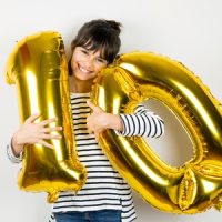 Ein Mädchen posiert mit Luftballons